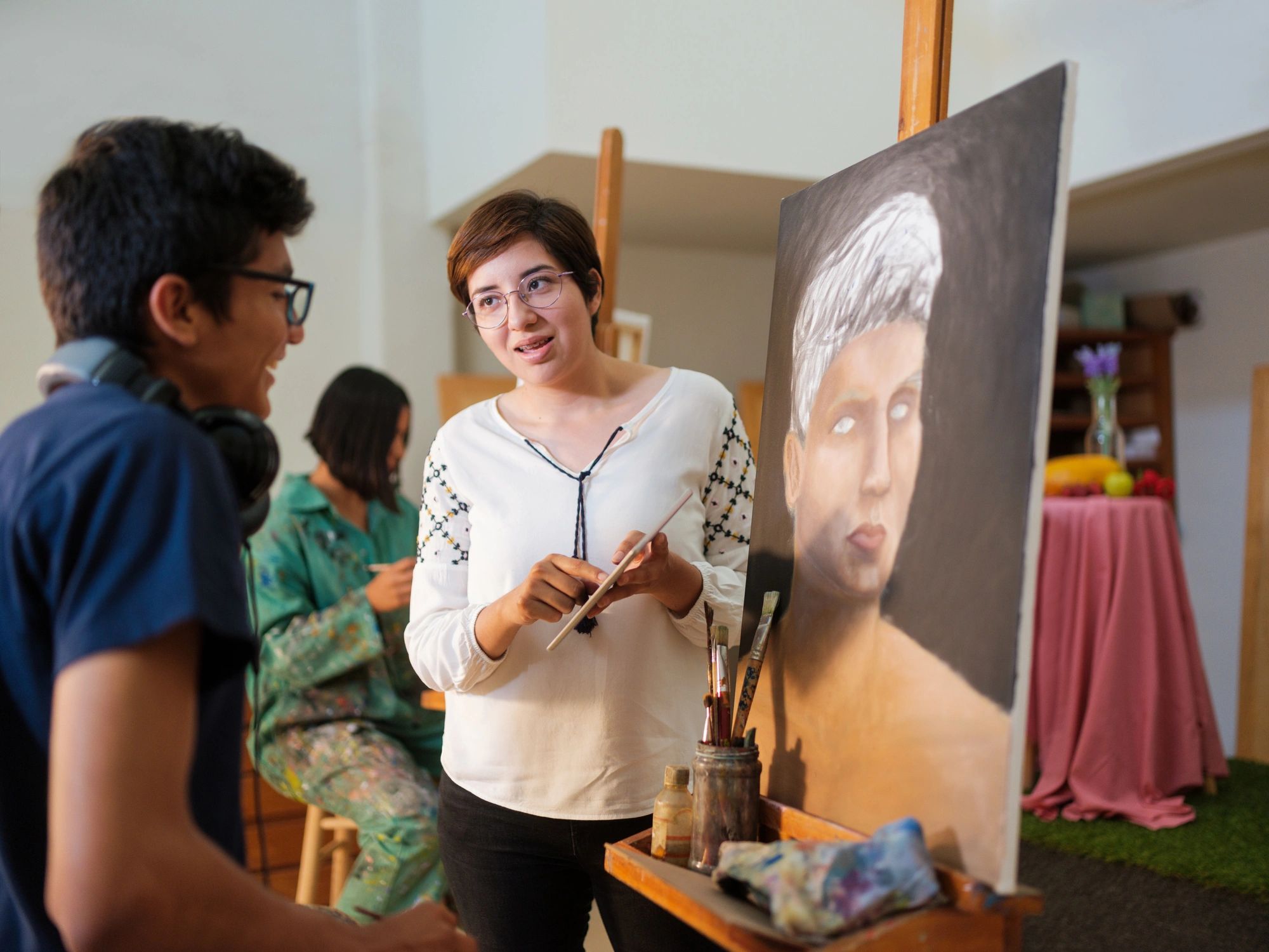 Female art instructor explaining art concept to student