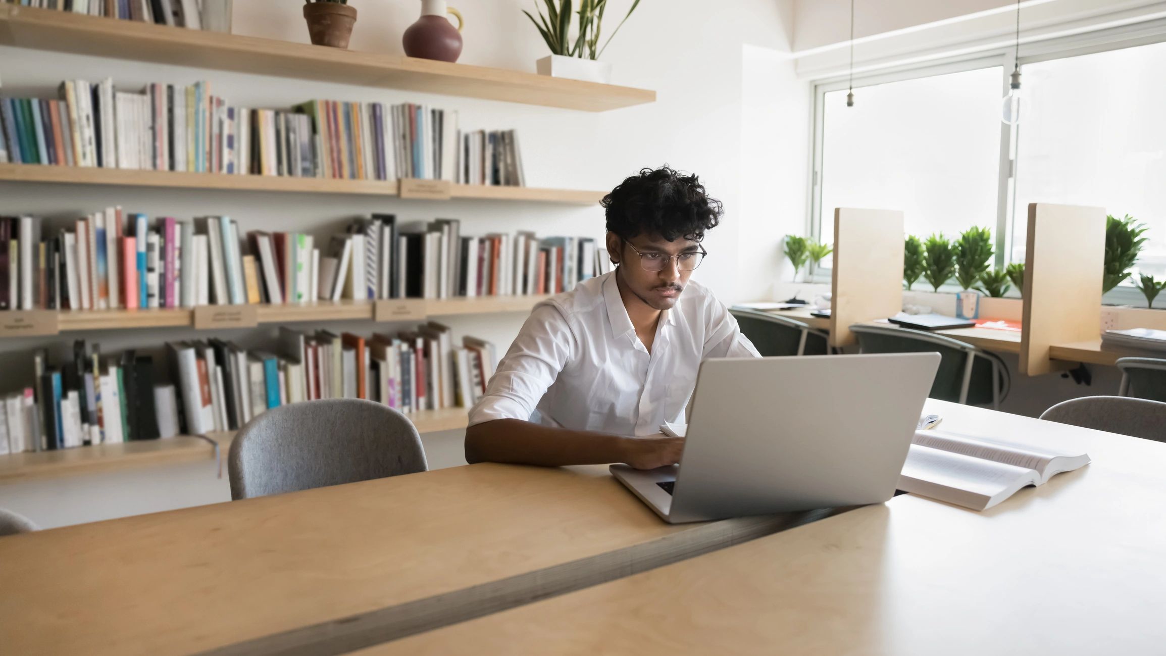 Serious Indian student man studying in public library